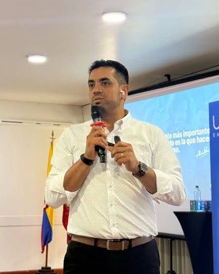 Alexis Peña presentando con micrófono en un evento