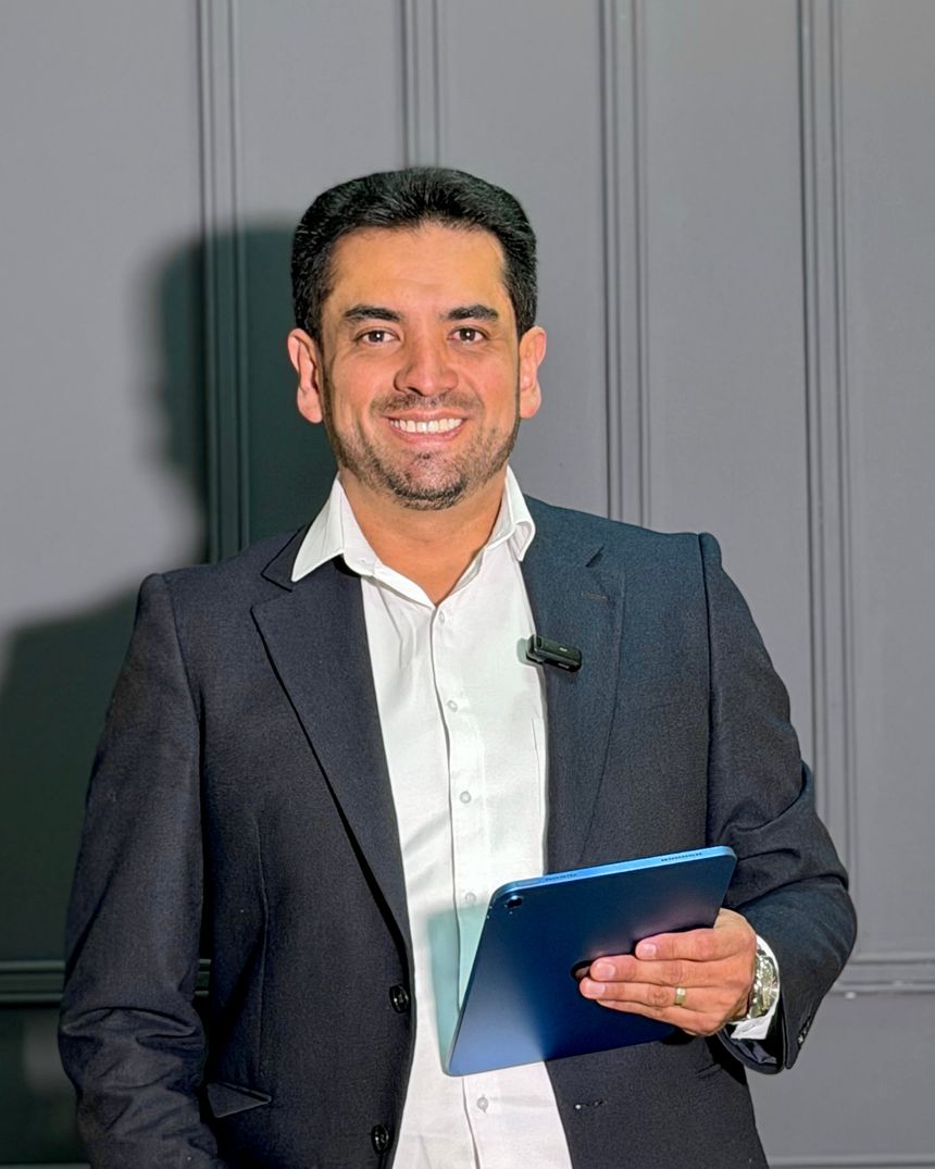 Retrato vertical de Alexis Peña, speaker de ventas, con tableta